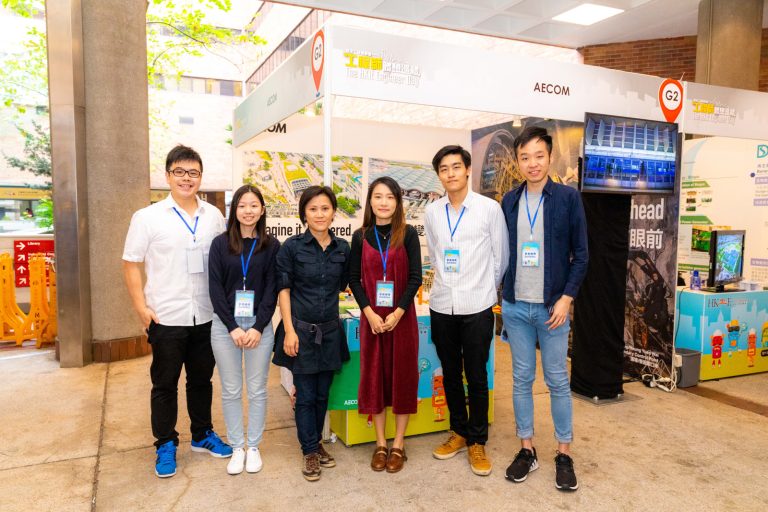 Six people posing together at an AECOM exhibition booth during The HKIE Engineer Day event.